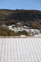 雪化粧したお隣の屋根と天王山の麓の家